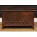 A 17th century oak six-plank chest, hinged top with notched ends, the front panel carved with