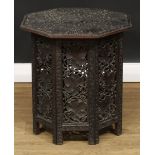 A hardwood Hoshiarpur type folding table, octagonal top carved with fruiting vine, the base with