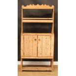 A pine dresser, of narrow proportions, shaped pediment above a plate rack/shelf and a pair of