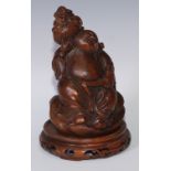 A Chinese bamboo figure, carved as Budai holding a basket of flowers, 19.5cm high, pierced