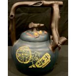 A Chinese terracotta tea kettle, with naturalistic branch handle and spout, glazed in blue with