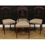 A set of four Edwardian dining chairs, each architectural-form splat carved with leaves and scrolls,