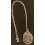 A silver mounted simulated ammonite pendant, set with a single polished amethyst, 5cm over