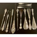 A collection of Victorian and later silver hafted shoe horns, button hooks and manicure tools