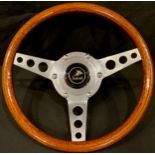 Automobilia - an Astrali mahogany and alloy three-spoke steering wheel, with central boss and badge,