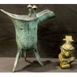 A Chinese verdigris paginated bronze tripod libation cup, cast in the archaic manner; a Chinese