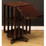 An early 20th century oak revolving bookcase, one side with an adjustable reading ledge, 92cm