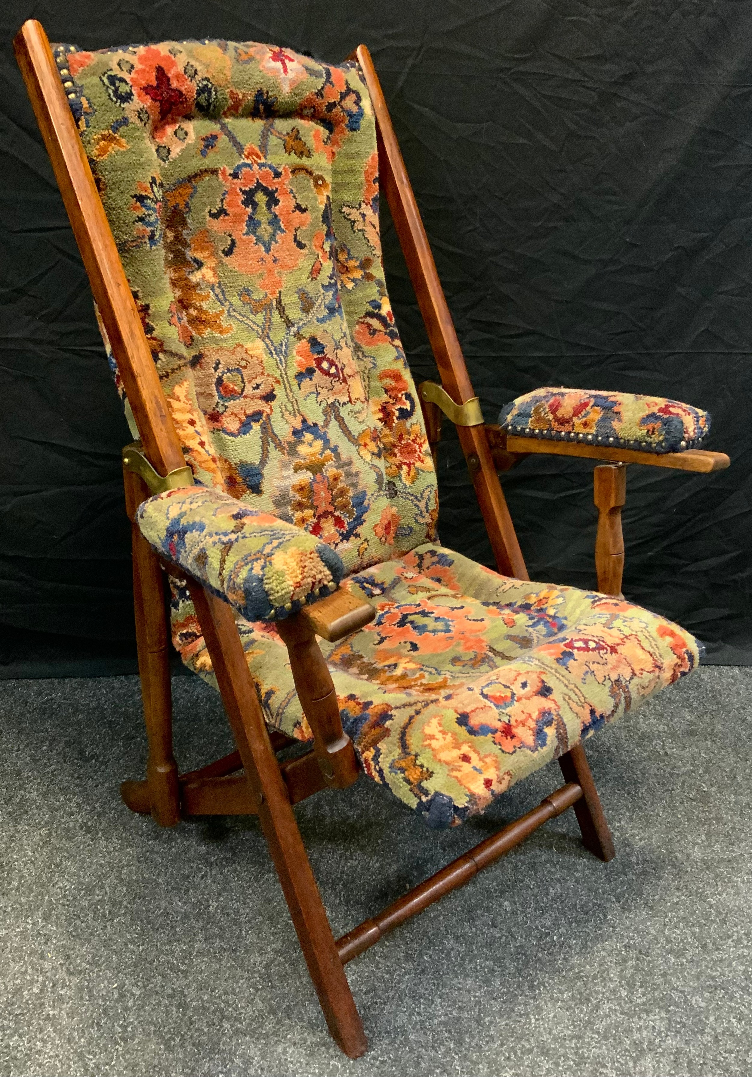 A late Victorian walnut campaign/steamer chair, slide pin action adjusters, floral upholstery, brass