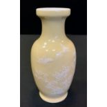 A 20th century Chinese vase, enamelled in white with stylised foliage, on a light yellow ground,