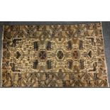 A Persian rug, decorated with animal and birds, flanking a row of three medallions, cream and