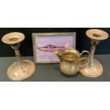 A pair of silver table candlesticks; a silver cream jug; a silver photograph frame (4)