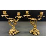 A pair of 19th century Rococo Revival ormolu two-light mantel candelabra, cast with a young courting