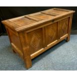 An 18th century oak blanket box, c.1740 three panelled top and front, carved with lunettes,