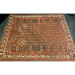 A Middle Eastern woollen rug, possibly Sarouk, with geometrical bands, intones of red, blue and