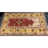 A Turkish Milas style woollen rug, rust central medallion, repeating geometric border, 214cm x 126cm