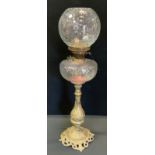 A Victorian oil lamp, clear glass reservoir, brass floral column, globular shade, 69cm high.