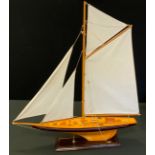 A model Yacht, single mast, wooden hull, 81cm high, 71cm long, with stand