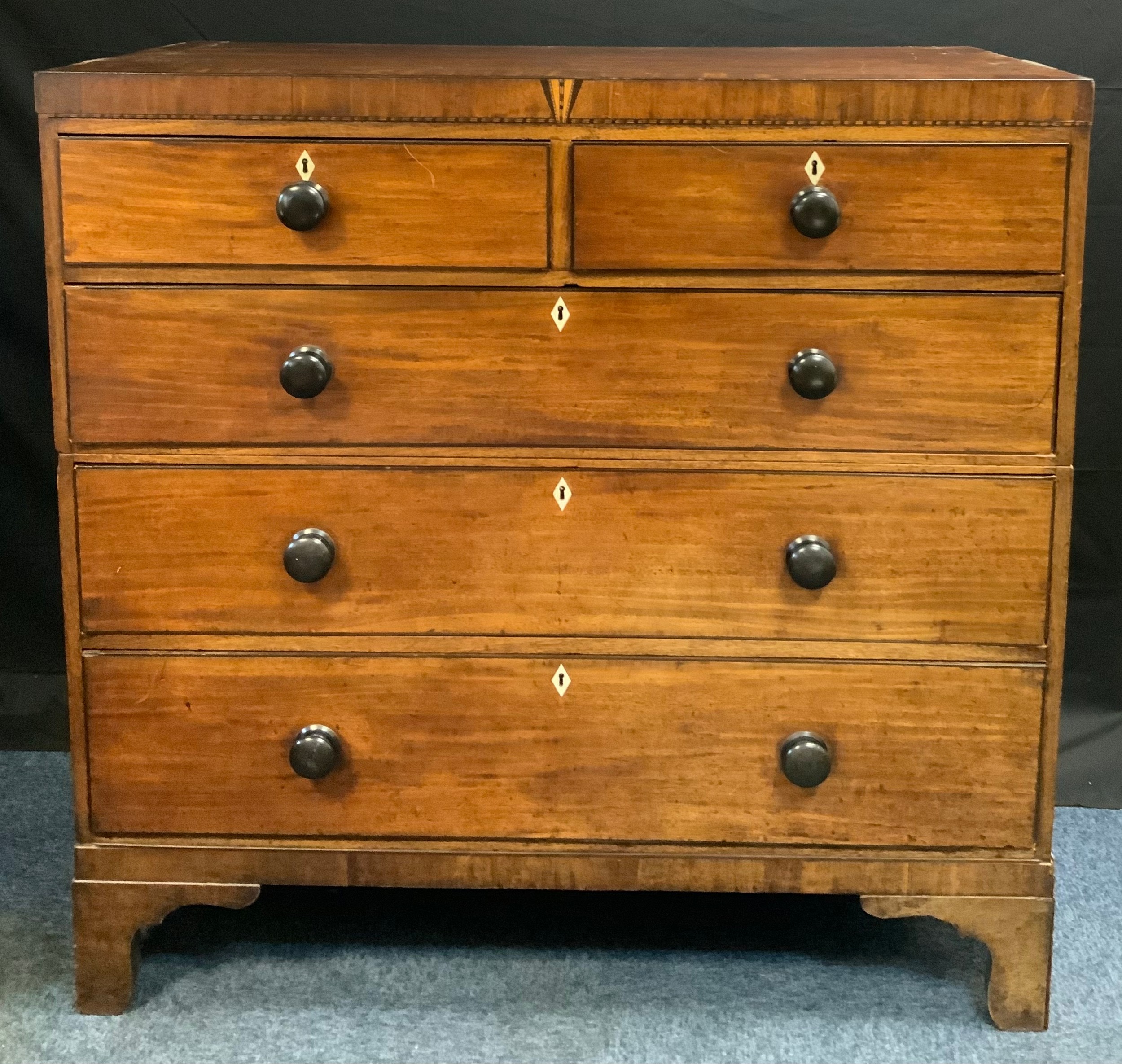 A 19th century mahogany chest, c.1820 outlined with ebony barber pole stringing, two short and three