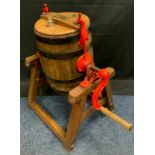 An early 20th century coopered oak butter churn, on stand, painted red ironwork, approx 80cm high