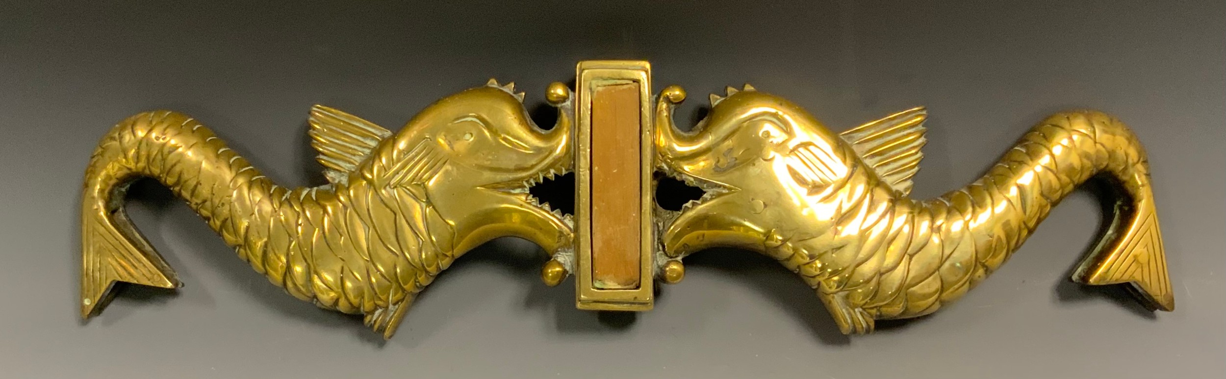 An Admiralty pattern brass Tiller Yoke, two opposing dolphins, spool inset tails, 54cm wide, c.1900