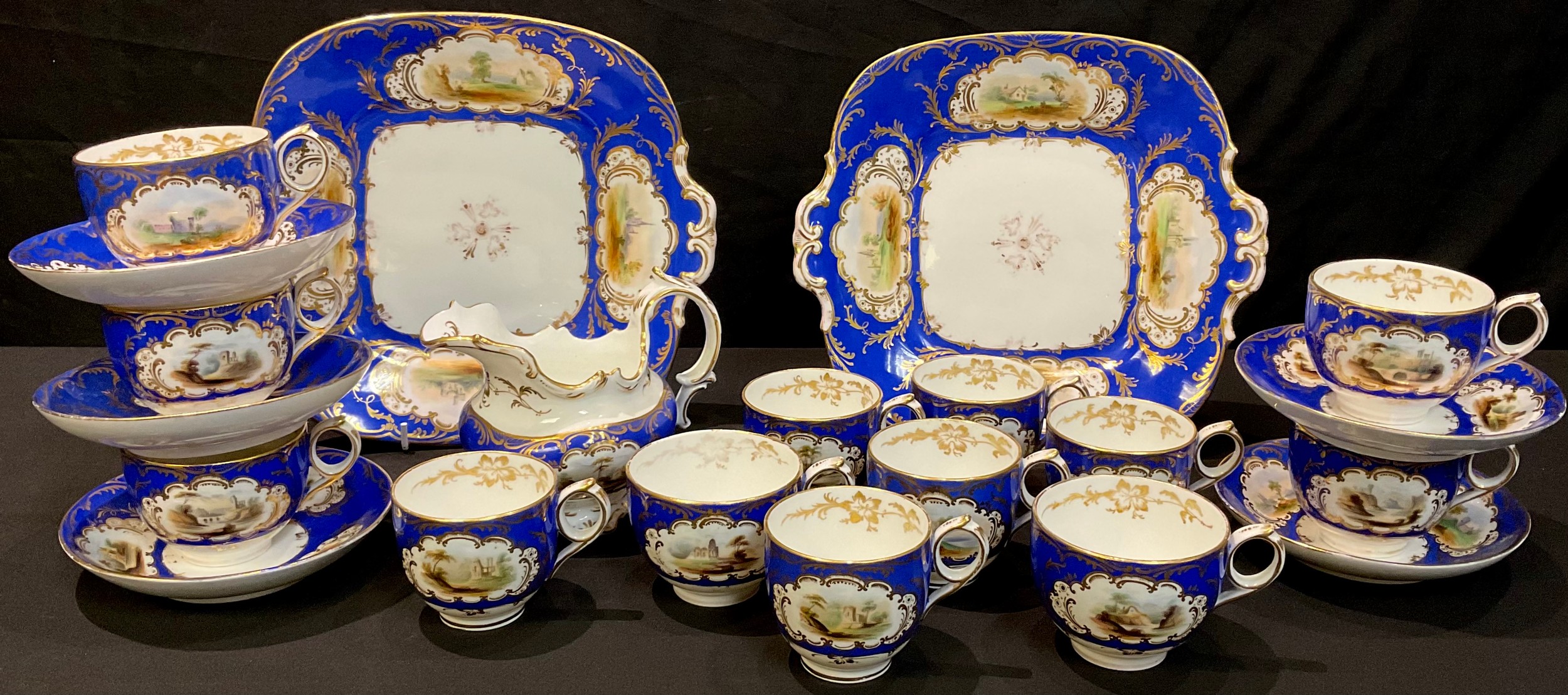 A 19th century Staffordshire part tea service, gilt edged panels painted with picturesque views on