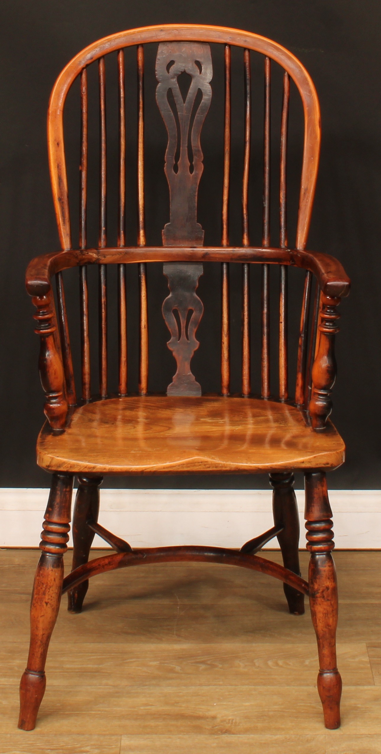 A 19th century yew and elm Windsor elbow chair, hoop back, shaped and pierced splat, one-piece mid-