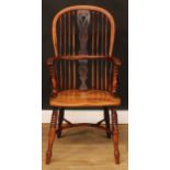 A 19th century yew and elm Windsor elbow chair, hoop back, shaped and pierced splat, one-piece mid-