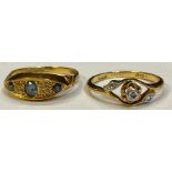 An 18ct gold three stone diamond crossover ring, size M/N, 2.3g; an 18ct gold sapphire and diamond