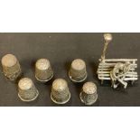 Six silver thimbles; a silver toy miniature model, of a courting couple on a bench (7)