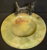 An Art Deco circular onyx dish, mounted with a cold painted bronze terrier playing with a ball, 11.