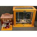 A set of laboratory scales, Griffin & George, London, cased; a miniature/child's sewing machine,