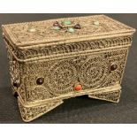 A Middle Eastern silver coloured metal casket, applied with filigree and set with turquoise, coral