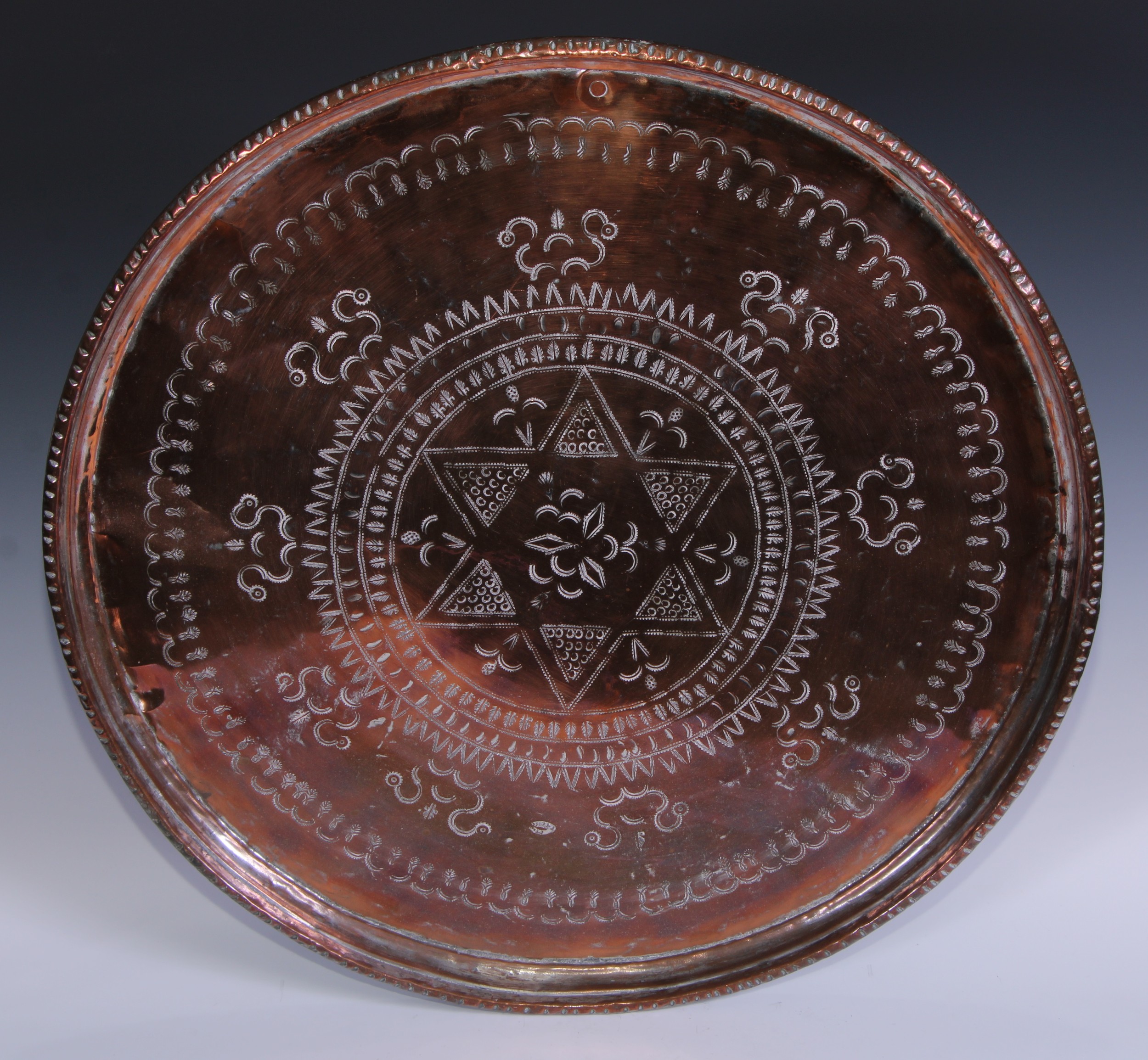 A large Persian circular copper charger, 61cm diam