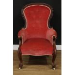 A Victorian mahogany spoonback armchair, boldly carved scroll arms, cabriole legs, ceramic