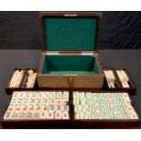 A Chinese Mahjong set, bone and bamboo pieces in fitted hardwood box, hinged cover, 24.5cm wide,