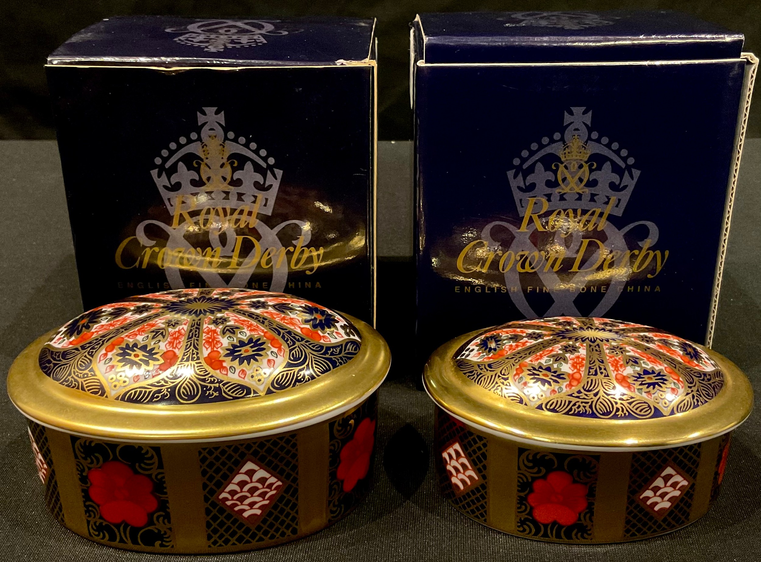 A Royal Crown Derby oval trinket pot and cover, solid gold band, first quality, 10cm wide, boxed;