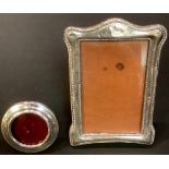 A George V silver oval easel photograph frame, Birmingham 1924; another, Birmingham 1901