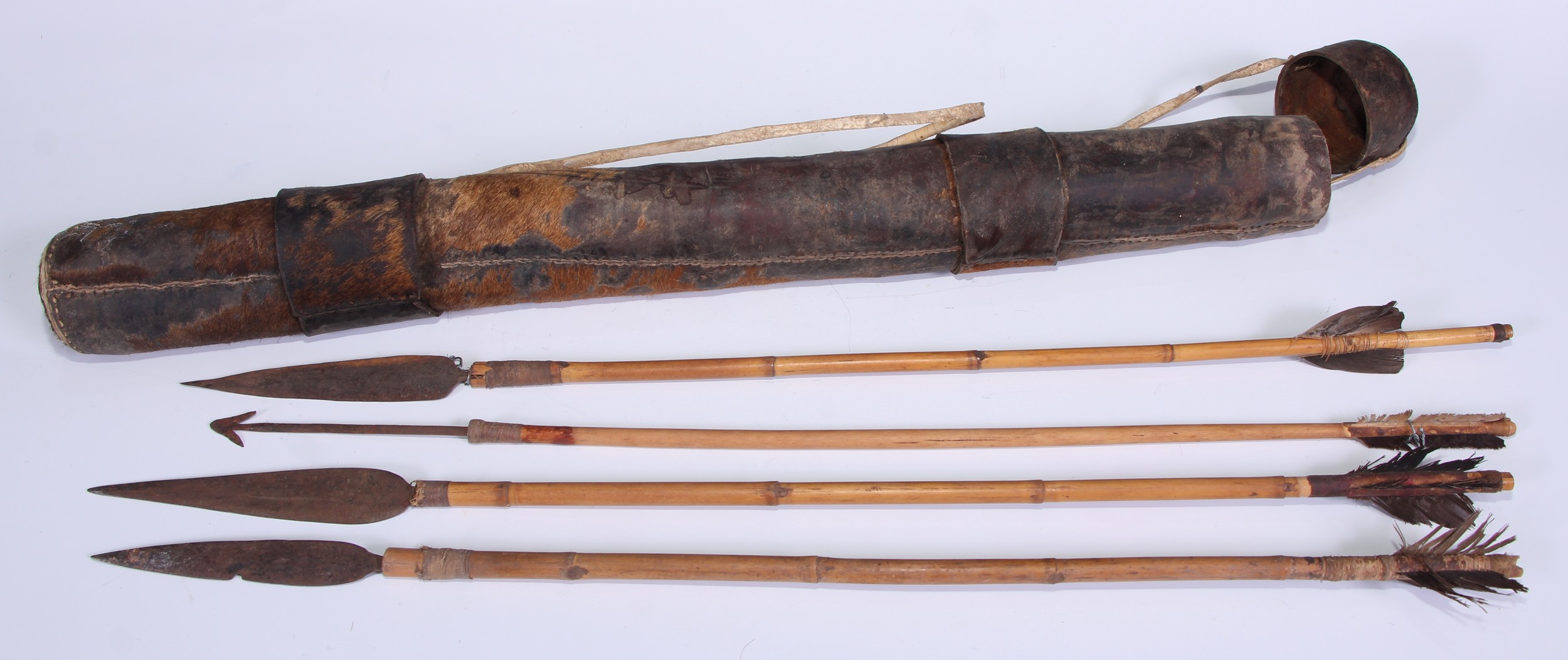 Tribal Art - an African boran hide quiver and cover, enclosing four bamboo arrows, various shapes