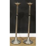 A pair of Arts & Crafts design floor-standing pricket candlesticks, 112cm high, the drip tray 21cm