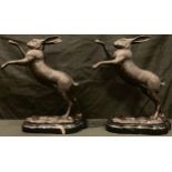 A pair of bronze boxing hares, shaped marble bases, 29cm high, late 20th century