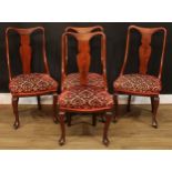 A set of four Queen Anne style dining chairs, each with a vasular splat, stuffed-over seat, cabriole