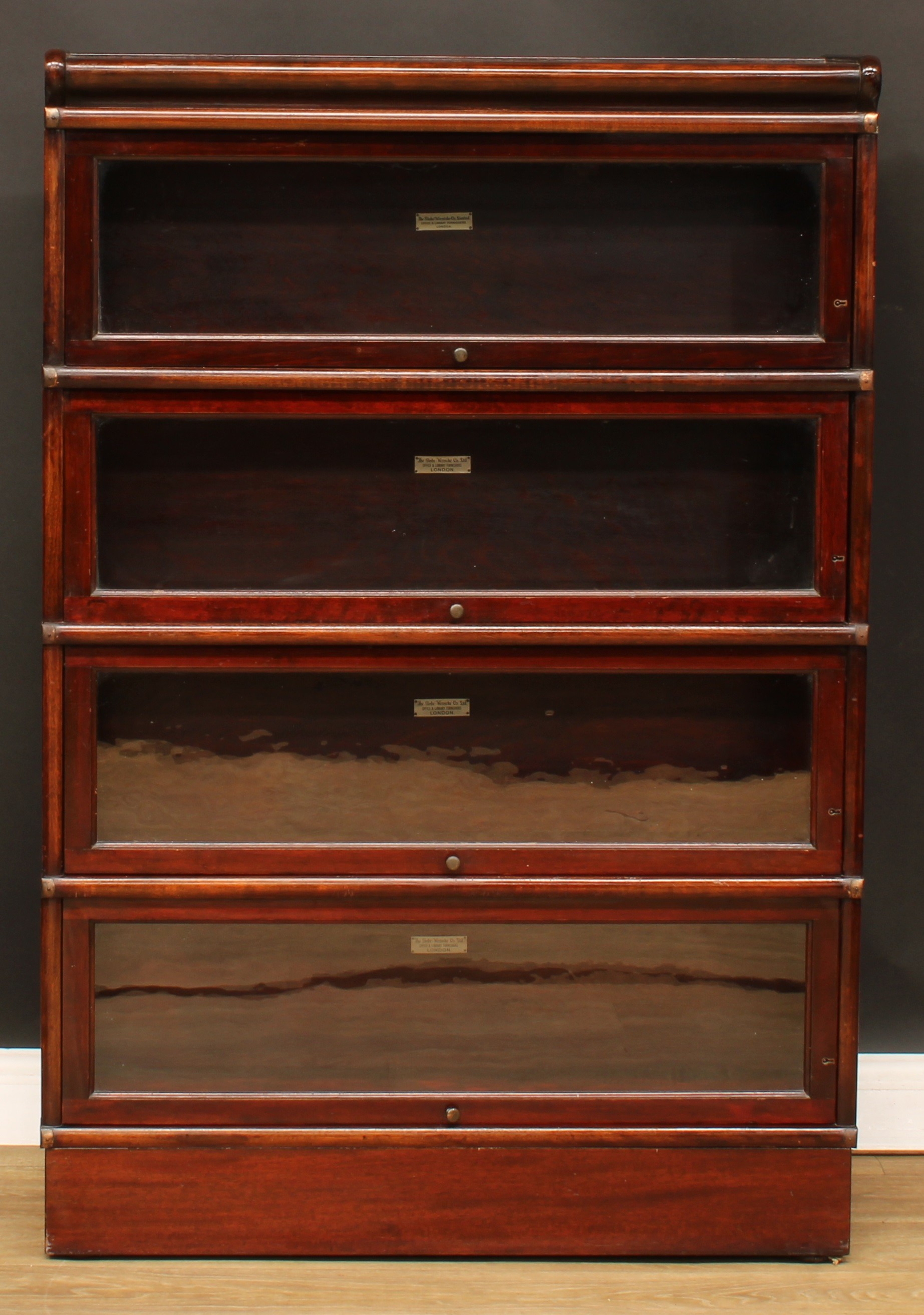 A Globe Wernicke barrister's bookcase, comprising four modular stacking sections, each bearing label
