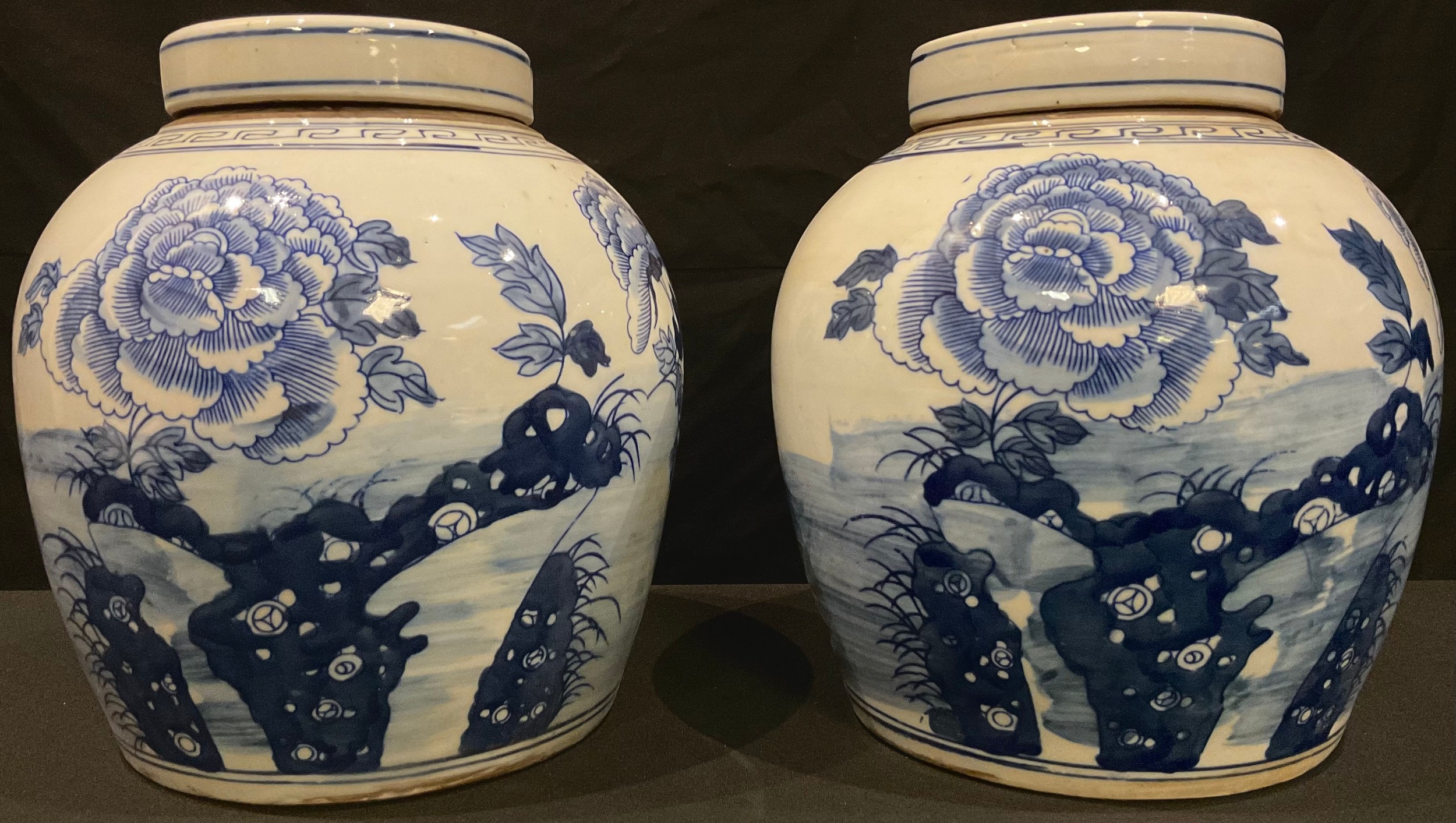 A pair of Chinese blue and white ginger jars and covers, each decorated with Chrysanthemums and