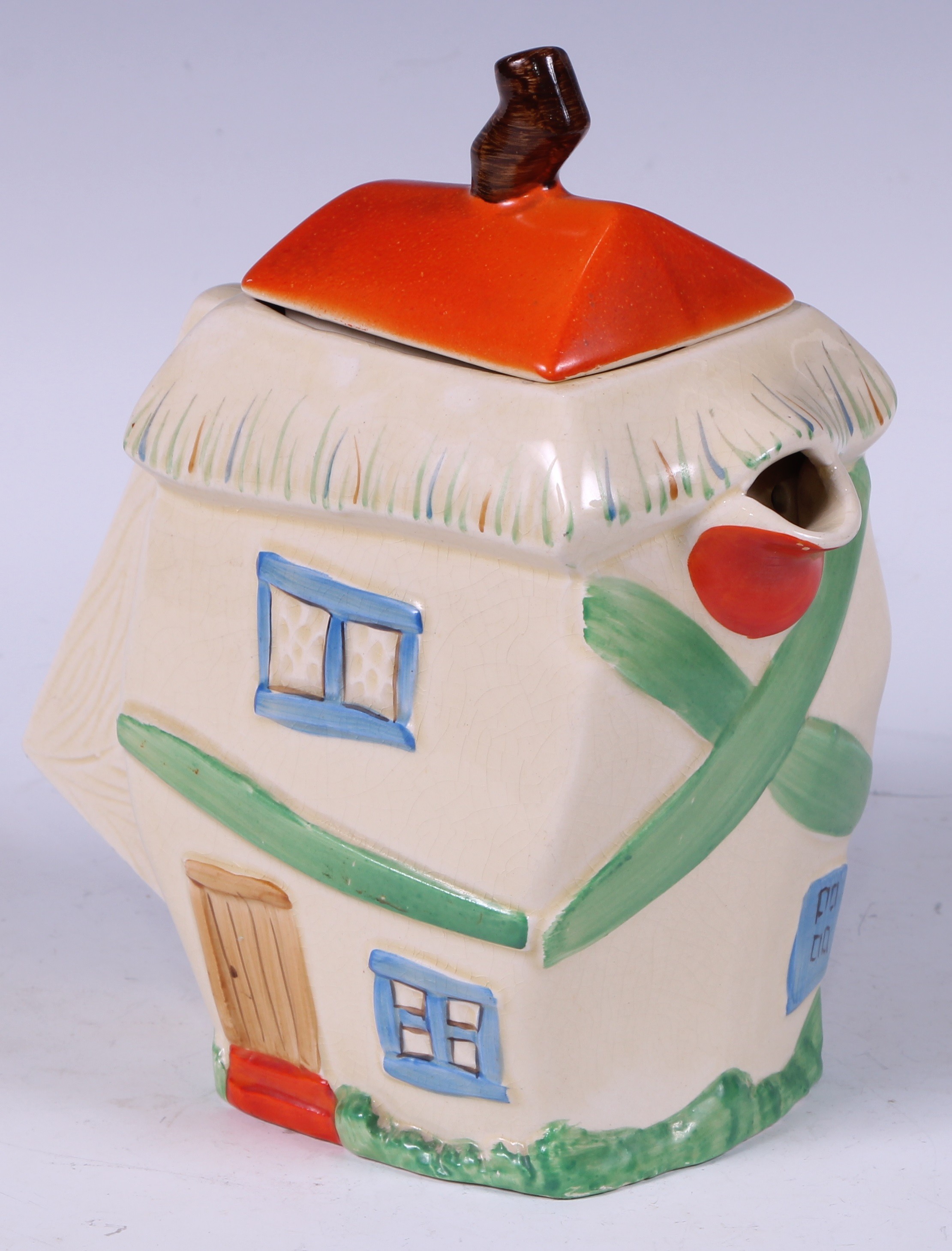 A Staffordshire hot water pot, as a crooked house, decorated in polychrome, angular handle, 19cm