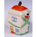 A Staffordshire hot water pot, as a crooked house, decorated in polychrome, angular handle, 19cm