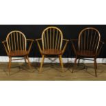 Three Ercol Windsor arm chairs, the largest 88.5cm high, 66.5cm wide, the seat 41cm wide and 35cm