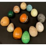 A polished specimen stone egg; others similar, malachite, onyx, wooden eggs, an Australian carved