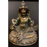 A gilt bronze model of a Deity, inset with coral and turquoise, 12cm high