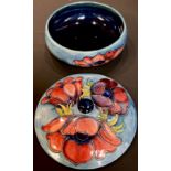A Moorcroft Anemone pattern circular bowl and cover, tube lined with flowerheads on a blue ground,