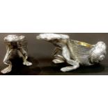 A pair of novelty silver plated table salts modelled as frogs pulling shells, 10cm wide